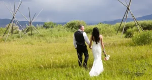 a newly married couple walks through the meadow at SpiriTaos