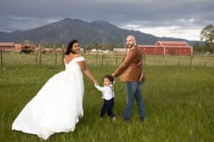 Couple and their child being photographed in the SpiriTaos Gardens meadow