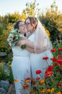 Loving brides kiss at the lovely SpiriTaos Gardens wedding venue