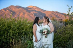 Brides posing in front of Taos Mountain at SpiriTaos Gardens