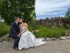 A couple exchanges a kiss while posing for a wedding portrait in the SpiriTaos Gardens
