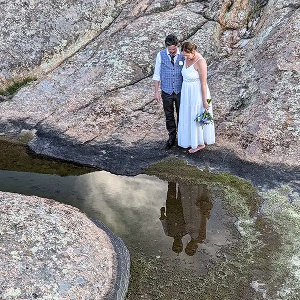 An adventurous couple gaze at their reflections for their wedding portrait