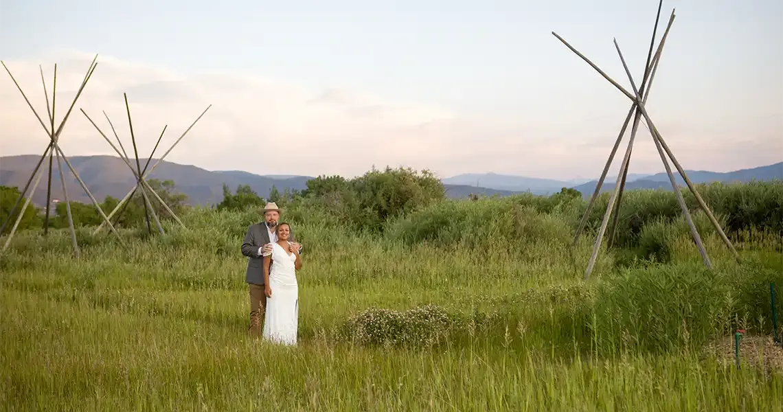 A couple poses in the meadow at SpiriTaos after their wedding