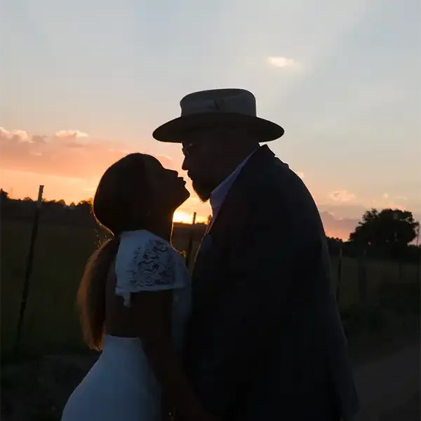 A sihouetted couple kiss against the setting sun in Taos NM