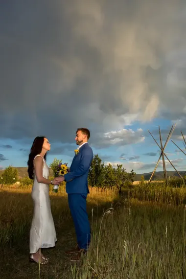 Evening light shines on the faces of the happy bride and groom