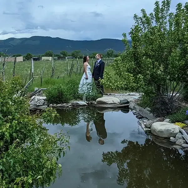 Couple poses for a portrait in front of the reflecting pond at SpiriTaos