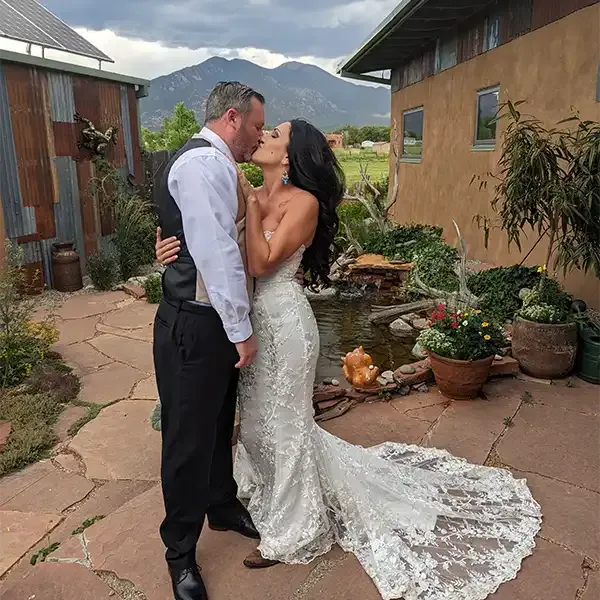 A brides wedding train swirls around her feet as she kisses her husband