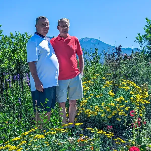 A newly married couple in polos and shorts poses after their very casual wedding