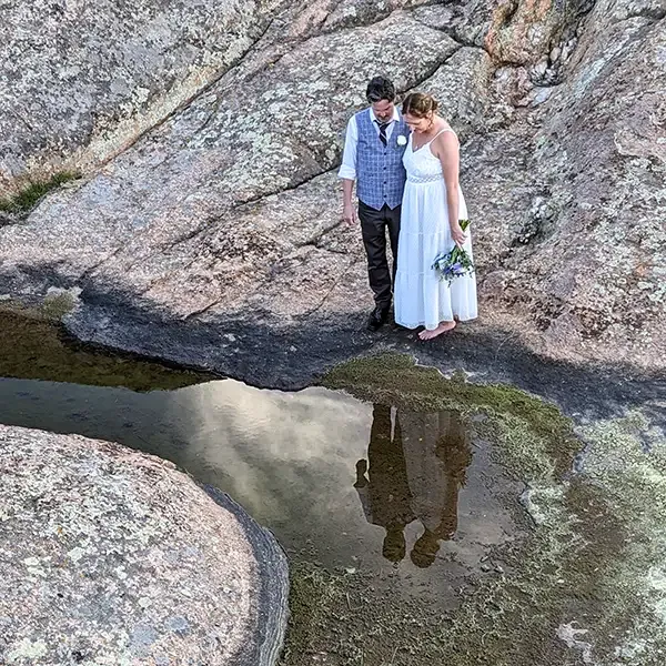 An adventurous couple gaze at their reflections for their wedding portrait