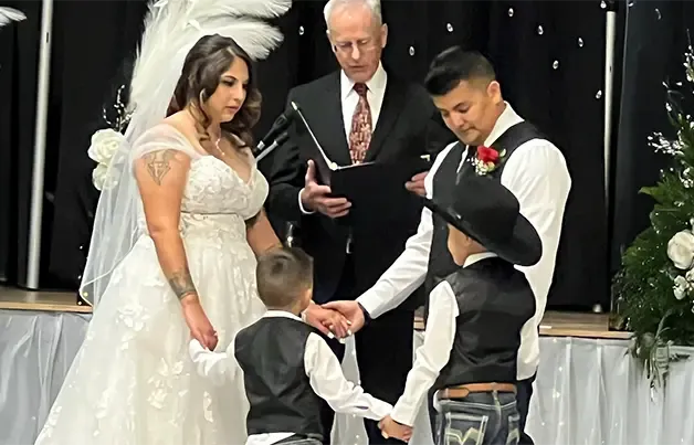 A family holds hands during a wedding ceremony