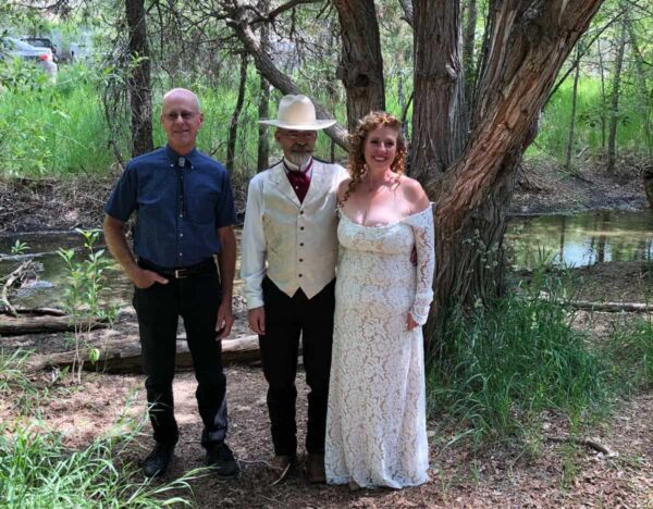 Dan posing for a photo with a newly married couple