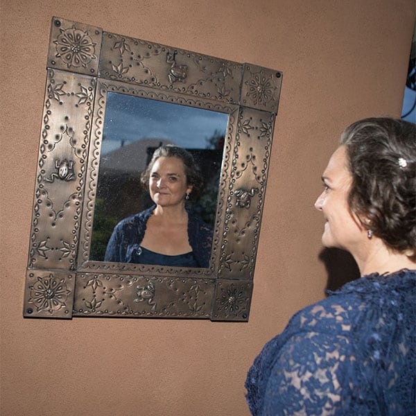 A bride smiles in the mirror at SpiriTaos wedding venue