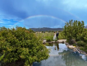 A rainbow hovers over a newly married couple at the Taos wedding venue SpiriTaos