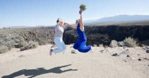 Happy brides leap for joy after their wedding by Dan Jones